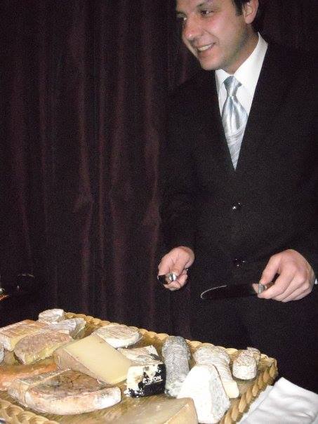 Waiter at fancy restaurant presenting a cheese plate in Paris.