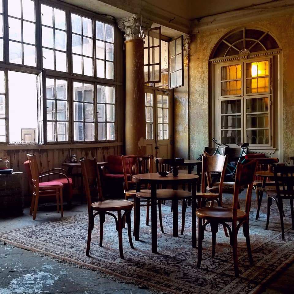 Coworking space at Halmi place in Kosice, Slovakia. Red velvet wooden chairs in an old room with big windows.