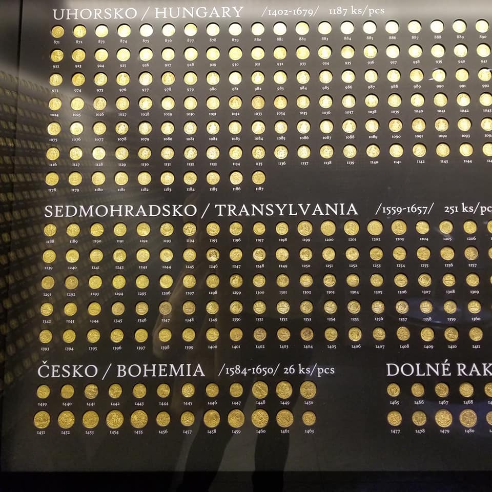 A display of the golden treasure of Kosice, Slovakia. There are between 2 and hundreds of golden coins displayed that were minted in different countries.