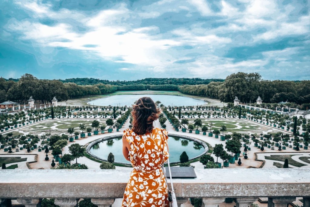 One of the best day trip from Paris - Woman looking out over gardens at Versailles