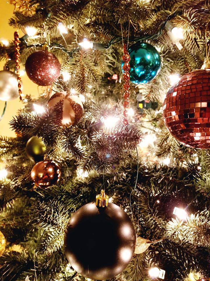 up close of christmas ornaments and lights on a tree